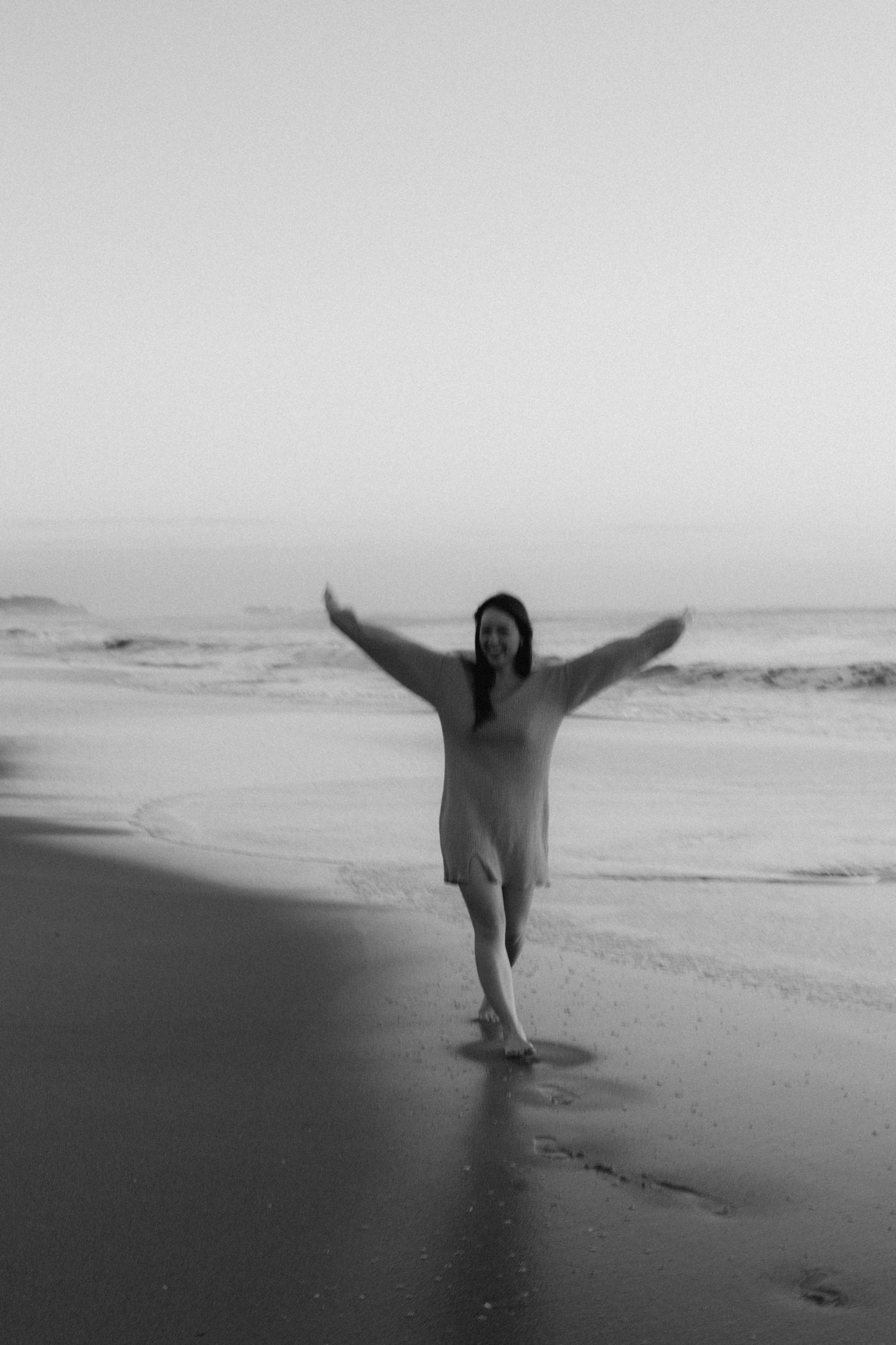Gabriela caminhando na praia em preto e branco